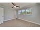 Light-filled bedroom with sleek ceiling fan, large windows, and neutral wall color at 4518 Helena Ne St, St Petersburg, FL 33703