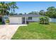 Charming single-story home with a well-manicured lawn, a stone driveway, and lush landscaping at 4518 Helena Ne St, St Petersburg, FL 33703