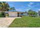 Charming home featuring a well-kept lawn, palm trees, and a stylish patterned driveway at 4518 Helena Ne St, St Petersburg, FL 33703