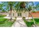Lush landscaping frames a white stucco building with a glass entryway and decorative flower planters at 4580 Overlook Ne Dr # 191, St Petersburg, FL 33703