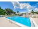 Community pool has multiple chairs and umbrellas for residents with a bright blue sky and clouds at 4580 Overlook Ne Dr # 191, St Petersburg, FL 33703