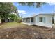 Wide shot of backyard showing green space, screened in porch, exterior, and garden beds at 4753 58Th N St, Kenneth City, FL 33709