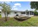 Exterior of home showcasing a white exterior, a screened porch and a small bricked patio in the backyard at 4753 58Th N St, Kenneth City, FL 33709