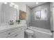 Bathroom features gray tiled shower, white vanity, toilet, and decorative mirror at 4753 58Th N St, Kenneth City, FL 33709