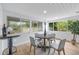 Bright breakfast nook with four chairs, a wood table, and a bar cart, surrounded by large windows at 4753 58Th N St, Kenneth City, FL 33709