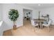 Open-concept dining area featuring a round table with four chairs and wood flooring with view to hallway at 4753 58Th N St, Kenneth City, FL 33709