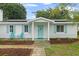Inviting facade with colorful shutters, solar panels, walkway, and covered entryway at 4753 58Th N St, Kenneth City, FL 33709