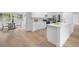 Spacious kitchen features white cabinetry, an island with quartz countertops, and hardwood floors at 4753 58Th N St, Kenneth City, FL 33709