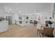 Open-concept living room with white brick fireplace, wood floors, and comfortable seating at 4753 58Th N St, Kenneth City, FL 33709