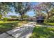 Charming home featuring an expansive driveway, secure fencing, and lush, mature landscaping at 489 W Davis Blvd, Tampa, FL 33606