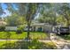 Charming single-story home with a well-maintained lawn, mature trees, and a black fence at 489 W Davis Blvd, Tampa, FL 33606