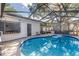 A refreshing pool with blue tiles, surrounded by a screened enclosure and ample deck space at 489 W Davis Blvd, Tampa, FL 33606