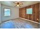 Cozy bedroom with stylish wood-paneled accent wall, complemented by wood-look floors and natural light at 4906 N Arrawana Ave, Tampa, FL 33614