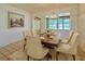 Bright dining room featuring a stylish chandelier and a table set for six, perfect for entertaining at 4906 N Arrawana Ave, Tampa, FL 33614