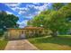 Charming single-story home featuring a well-manicured lawn and mature trees providing ample shade at 4906 N Arrawana Ave, Tampa, FL 33614