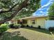 Charming single-story home with lush landscaping and mature trees providing shade and curb appeal at 4906 N Arrawana Ave, Tampa, FL 33614