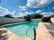 Refreshing in-ground pool surrounded by a spacious patio, perfect for outdoor relaxation and entertaining at 4906 N Arrawana Ave, Tampa, FL 33614