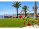 Lush backyard with manicured lawn, blooming roses, palm trees and views of the waterfront at 501 Brightwaters Ne Blvd, St Petersburg, FL 33704