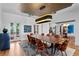 Elegant dining room featuring a large wood table, velvet chairs, modern light fixture, and access to an outdoor area at 501 Brightwaters Ne Blvd, St Petersburg, FL 33704