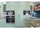 Kitchen features custom green cabinetry, integrated appliances, and convenient built-in coffee machine at 501 Brightwaters Ne Blvd, St Petersburg, FL 33704