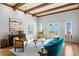 Bright living room with water views, light hardwood floors, an eclectic mix of furniture, and decorative beamed ceiling at 501 Brightwaters Ne Blvd, St Petersburg, FL 33704