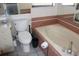 A clean bathroom featuring a tub with red tile accents and a nearby toilet and vanity at 5581 Greyston St, Palm Harbor, FL 34685