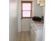 Laundry area with washer and dryer, a window covered by blinds, and tile flooring at 5581 Greyston St, Palm Harbor, FL 34685