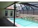 A sparkling swimming pool with a screen enclosure, stone accents, and patio area at 5581 Greyston St, Palm Harbor, FL 34685