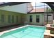 A sparkling swimming pool with a screen enclosure, stone accents, and patio area at 5581 Greyston St, Palm Harbor, FL 34685