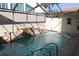 Inviting in-ground pool with waterfall feature, screen enclosure, and covered patio at 5581 Greyston St, Palm Harbor, FL 34685