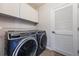 Laundry room with modern washer and dryer, complemented by upper cabinets for storage at 575 53Rd N Ave, St Petersburg, FL 33703