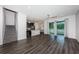 Open-concept living room features gray floors, a ceiling fan, and sliding glass doors for natural light at 575 53Rd N Ave, St Petersburg, FL 33703