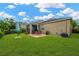 Spacious backyard featuring a well-maintained lawn, a patio with table and chairs, and privacy landscaping at 5806 Tulip Flower Dr, Riverview, FL 33578