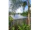 Scenic backyard view featuring a calm lake, bordered by lush greenery and a charming wooden fence at 5806 Tulip Flower Dr, Riverview, FL 33578