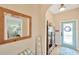 Inviting entryway with a decorative mirror, cabinet, and front door with glass detailing at 5806 Tulip Flower Dr, Riverview, FL 33578