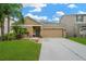 Charming single-story home with a well-manicured lawn and tropical landscaping at 5806 Tulip Flower Dr, Riverview, FL 33578