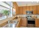 This kitchen features stainless steel appliances, granite countertops, and natural wood cabinets at 5806 Tulip Flower Dr, Riverview, FL 33578