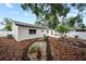 Well-maintained backyard with a patio, garden beds, and lush landscaping, ideal for outdoor enjoyment at 6204 Walsh Ln, Tampa, FL 33625