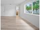 Bright bedroom featuring hardwood floors, fresh white walls, and a bathroom view with modern finishes at 6204 Walsh Ln, Tampa, FL 33625
