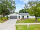 Charming single-story home with gray garage door, arched windows, brick accents, and well-manicured lawn at 6204 Walsh Ln, Tampa, FL 33625