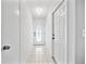 Bright hallway with neutral walls, tile floors, decorative glass front door and modern lighting at 6204 Walsh Ln, Tampa, FL 33625