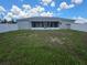 View of the back of the home, backyard, and screened in porch at 7056 Landover Blvd, Spring Hill, FL 34608