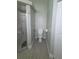 This bathroom includes a toilet, tile flooring, and a shower with glass door at 7056 Landover Blvd, Spring Hill, FL 34608