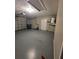 A wide garage with a utility door, water heater, and concrete flooring at 7056 Landover Blvd, Spring Hill, FL 34608