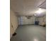 Spacious garage with roll-up door, concrete floors, and space for storage at 7056 Landover Blvd, Spring Hill, FL 34608