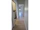 Hallway with wood floors leading to laundry room and bedrooms at 7056 Landover Blvd, Spring Hill, FL 34608