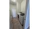 Well-lit laundry room with washer, dryer, tiled floor, and utility sink at 7056 Landover Blvd, Spring Hill, FL 34608