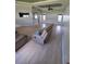 Open-concept living room featuring wood floors, large windows, and ceiling fan at 7056 Landover Blvd, Spring Hill, FL 34608