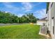 Spacious backyard featuring a lush green lawn, privacy fence, and hot tub at 7737 Rosewood Garden Loop, Tampa, FL 33637