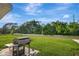 Large backyard featuring green lawn and grill at 7737 Rosewood Garden Loop, Tampa, FL 33637